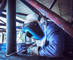 Welder works on steel pipe